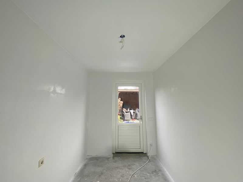 Kamer met wit latex spuitwerk op de wanden en het plafond
